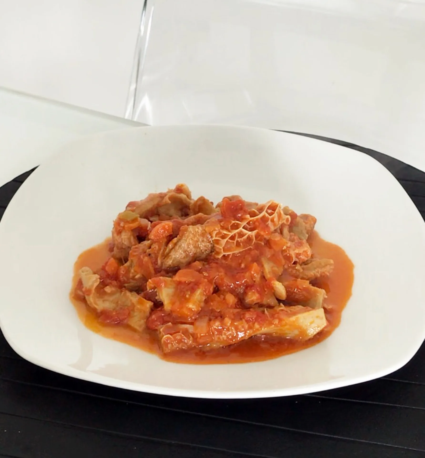 Callos guisados con tomate, servidos en un plato blanco